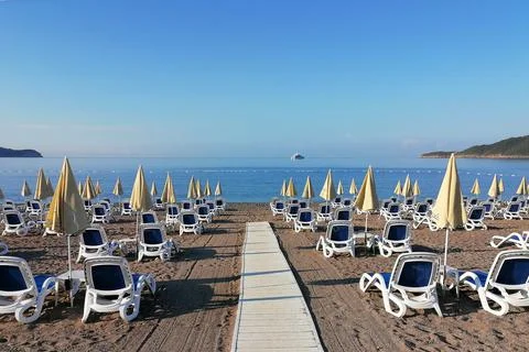 Sandy beach with deck chairs and umbrellas Stock Photos