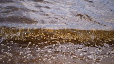 Sandy beach with fine waves that have white foam crests Stockbeeldmateriaal 94682418