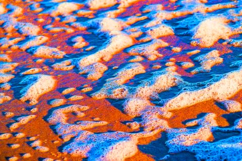 Sandy beach with foam of the surf Stock Photos