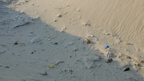Sandy beach full of trash, man made pollution , pan shot Video stock 109506595