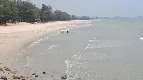Sandy Beach with Gentle Waves and Visitors Stock Photos