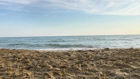 Sandy Beach with Gentle Waves under Partly Cloudy Sky Stock Footage 340602714