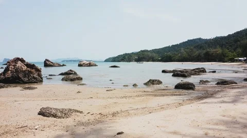 Sandy beach at low tide with sea views and large rocks Stock Footage 134710049