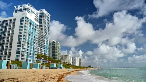 Sandy beach with multi-storied buildings. White clouds in the blue sky. Miami, Stock Footage 332809906