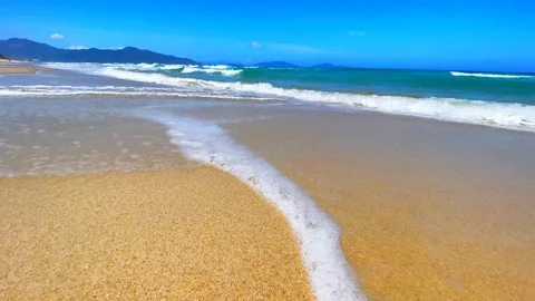 A sandy beach next to the ocean, tropical island beach, blue turquoise sea water Stock Footage 128827119