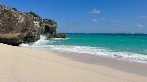 Sandy beach next to a rocky cliff, massive waves hitting beach and cliff Vídeos de archivo 321405948