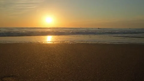 Sandy beach with rolling waves during sunset in summer. Stock Footage 303585010
