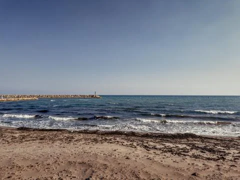 Sandy beach with rolling waves under a dramatic open sky 库存照片