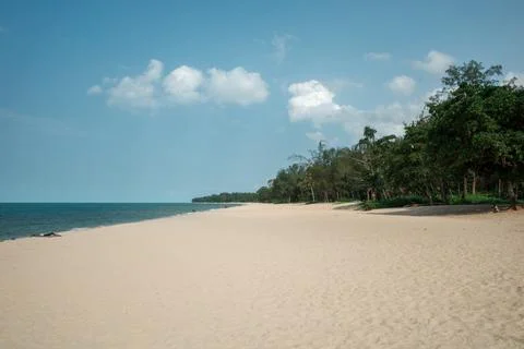 Sandy beach stretches under clear blue sky Stock Photos