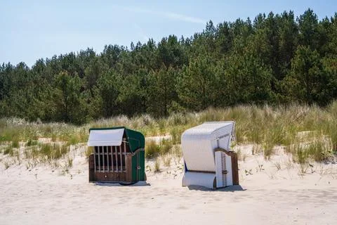 On the sandy beach there are two strandkorbs facing in different directions Stock Photos