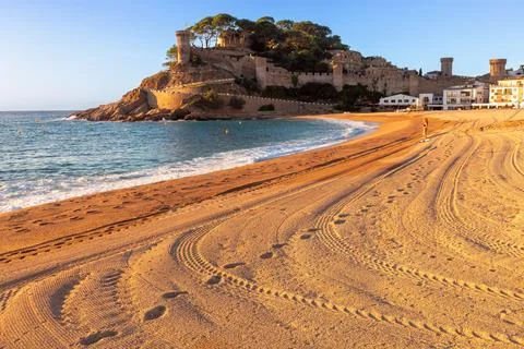 Sandy beach of Tossa de Mar at sunrise, Spain Stock Photos