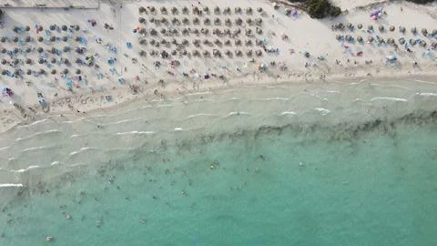 Sandy beach with a vast array of colorful umbrellas neatly lined up and the crys Fotos de archivo