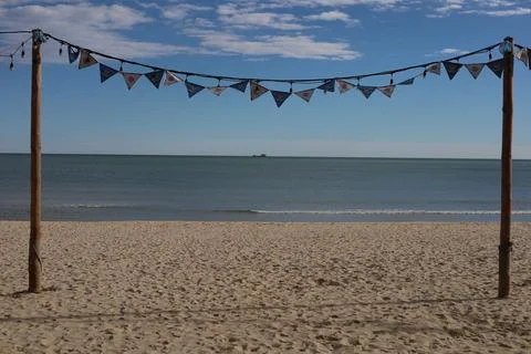Sandy beach view with cargo ship in distance Stock Photos