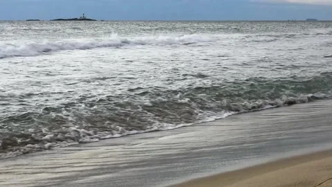 Sandy beach view with waves and lighthouse in the background Stock-Footage 161824577
