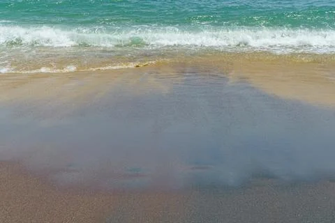 Sandy beach with waves and wet sand Stock Photos