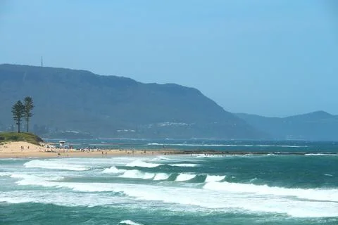 Sandy Beach With Waves Rolling In From The Blue Ocean Under A Clear Blue Sk.. Stock Photos