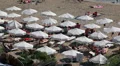 Sandy beach with white parasols and sunbeds full of people, Coral Bay, Cyprus HD Footage