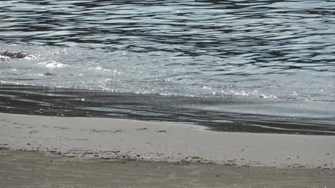 Sandy beachfront ocean water summer day with reflection of light on water. Stock Footage 287897577