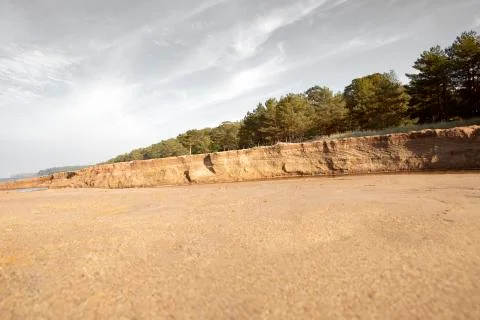 Sandy bed of a small stream with a vertical, high bank Stock Photos