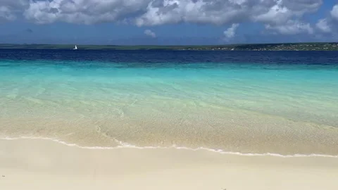 Sandy deserted tropical beach with turquoise sea and blue sky with clouds. Stock-Footage 183993036