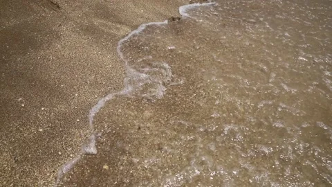Sandy Footprints Being Washed Away On The Beach By An sea Wave Stock Footage 136516906