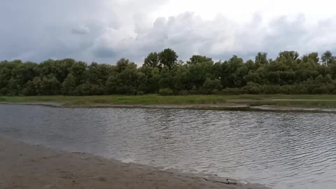 A sandy, gently sloping bank of a small channel bordered by a strip Stock Footage 333252122