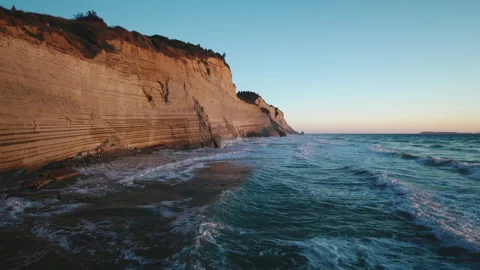 Sandy high cliff and coast by Mediterranean sea with waves and wind at sunset Stock Footage 279555437