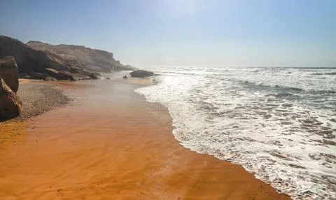 Sandy ocean and beach at sunset. Beautiful orange coast line. Oceanic seascape Stockfoto's