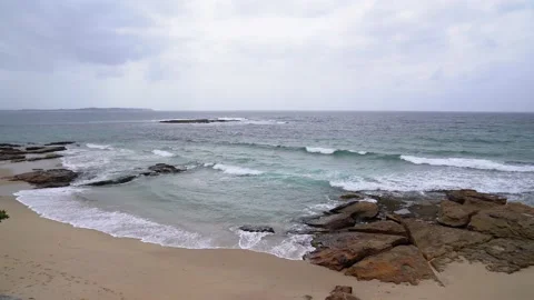Sandy ocean beach with rocks and waves Stock Footage 130884187