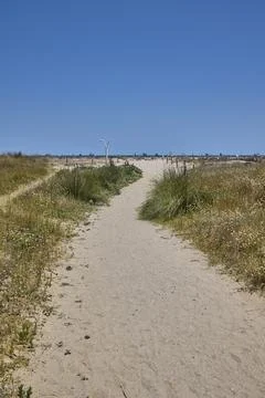 Sandy path leading through coastal dunes to Mediterranean beach in Spain Stock Photos