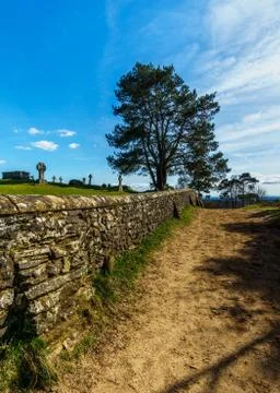 A sandy path with a rustic brick wall on a sunny day in the Surrey Hills Stock Photos