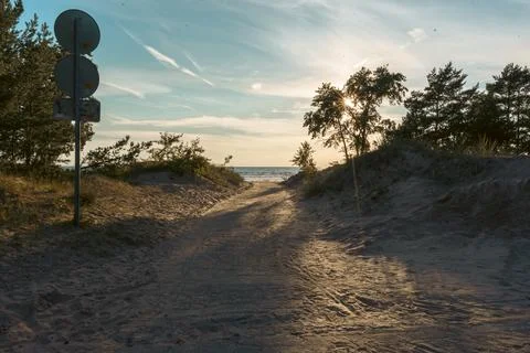 Sandy path through dunes leading to the beach at sunset Stock Photos