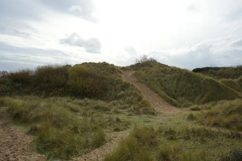 Sandy Path Through Marram Grass Dunes At Talacre Beach, North Wales Under Cloudy Stock Photos