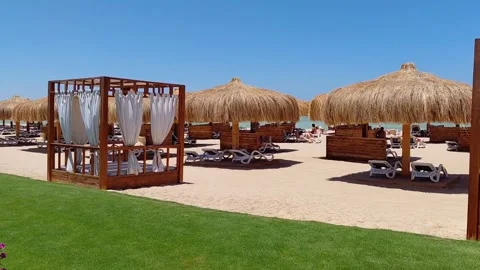 Sandy resort beach with straw umbrellas and cabanas in Tropitel Sahl Hasheesh. Stock Footage 337533380