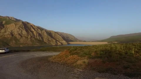Of a sandy road in green landscape with river stream beside, stock footage. Stock Footage 304796314