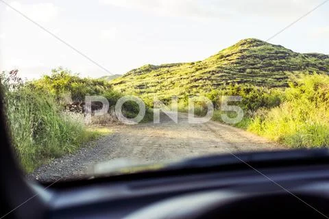 Sandy road viewed through car windshield Stock Photos