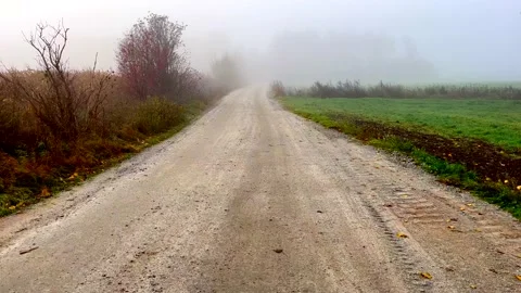 Sandy rural road through fields in misty landscape. Stock Footage 220033828