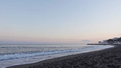 Sandy seashore with pebble and blue sea waves at sunset 動画素材 169840089