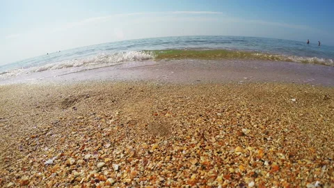 Sandy seashore with small shells and light waves running over it 库存影片 105187695