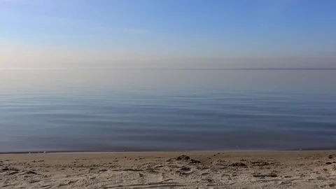 Sandy seashore, small waves, calm blue sea water, clear sky, day on the beach Video stock 124648886