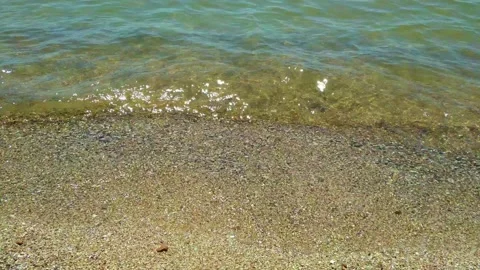 Sandy seashore, small waves wash the shore. Beach vacation, sunny day. Stock Footage 137199471