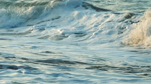 Sandy seashore at sunset. Foamy waves run ashore. A picturesque corner on a t Stock Footage 119524560