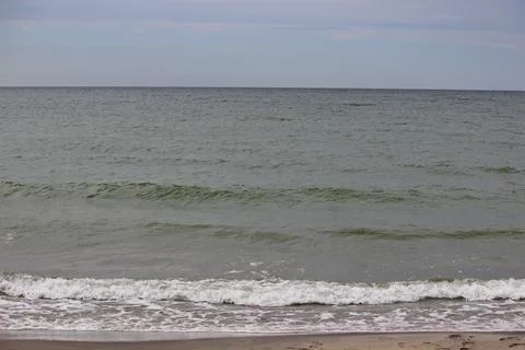 Sandy seashore white waves, soft sunlight, idyllic seascape Stock Photos