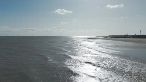 Sandy shore meets gentle waves under bright sky Stock Footage 346257490