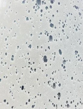 Sandy surface with dark water spots seen from above during daytime Stock Photos
