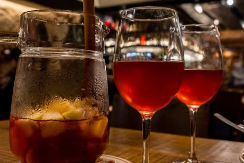 Sangria Pitcher with two glasses lined up on a wooden table. Stock Photos