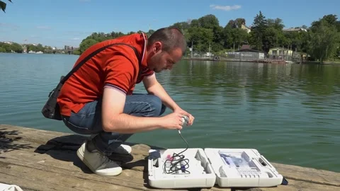 Sanitary service officer testing river water quality during hot summer heatwave. Stock Footage 342118255