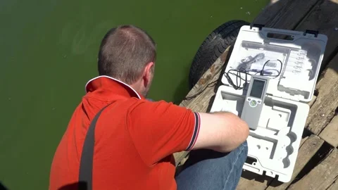Sanitary service officer testing river water quality during hot summer heatwave. Stock Footage 342118290