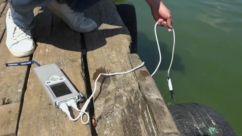 Sanitary service officer testing river water quality during hot summer heatwave. Stock Footage 342118297