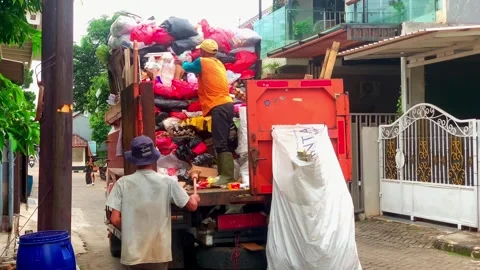A sanitation worker loads household waste Stock Footage 329902852